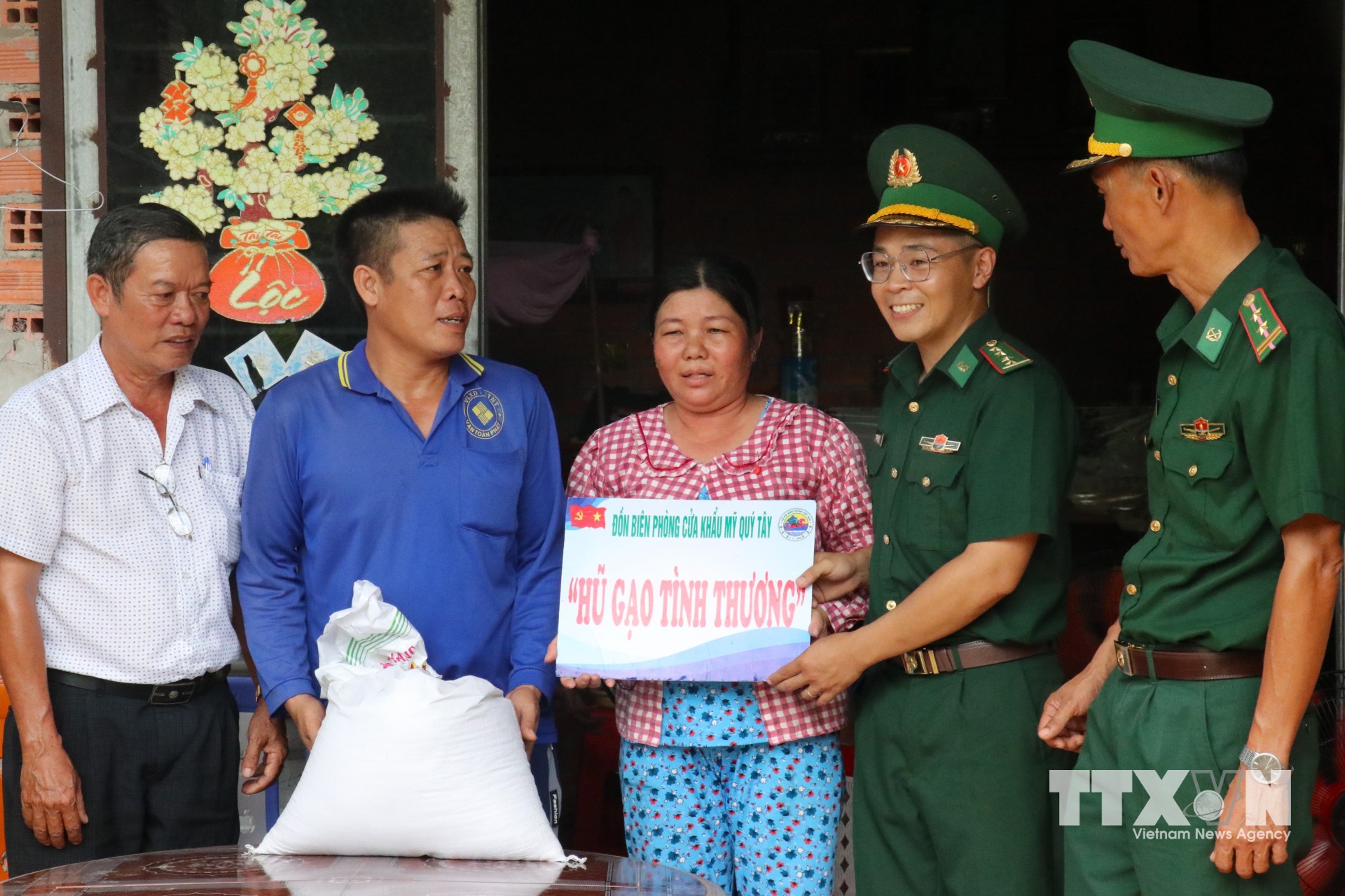 Đại úy Phạm Việt Tiến trao “Hũ gạo tình thương” hỗ trợ gia đình có hoàn cảnh khó khăn trên địa bàn, góp thêm sự sẻ chia và gắn kết giữa người lính biên phòng với nhân dân vùng biên. (Ảnh: Bùi Giang/TTXVN)